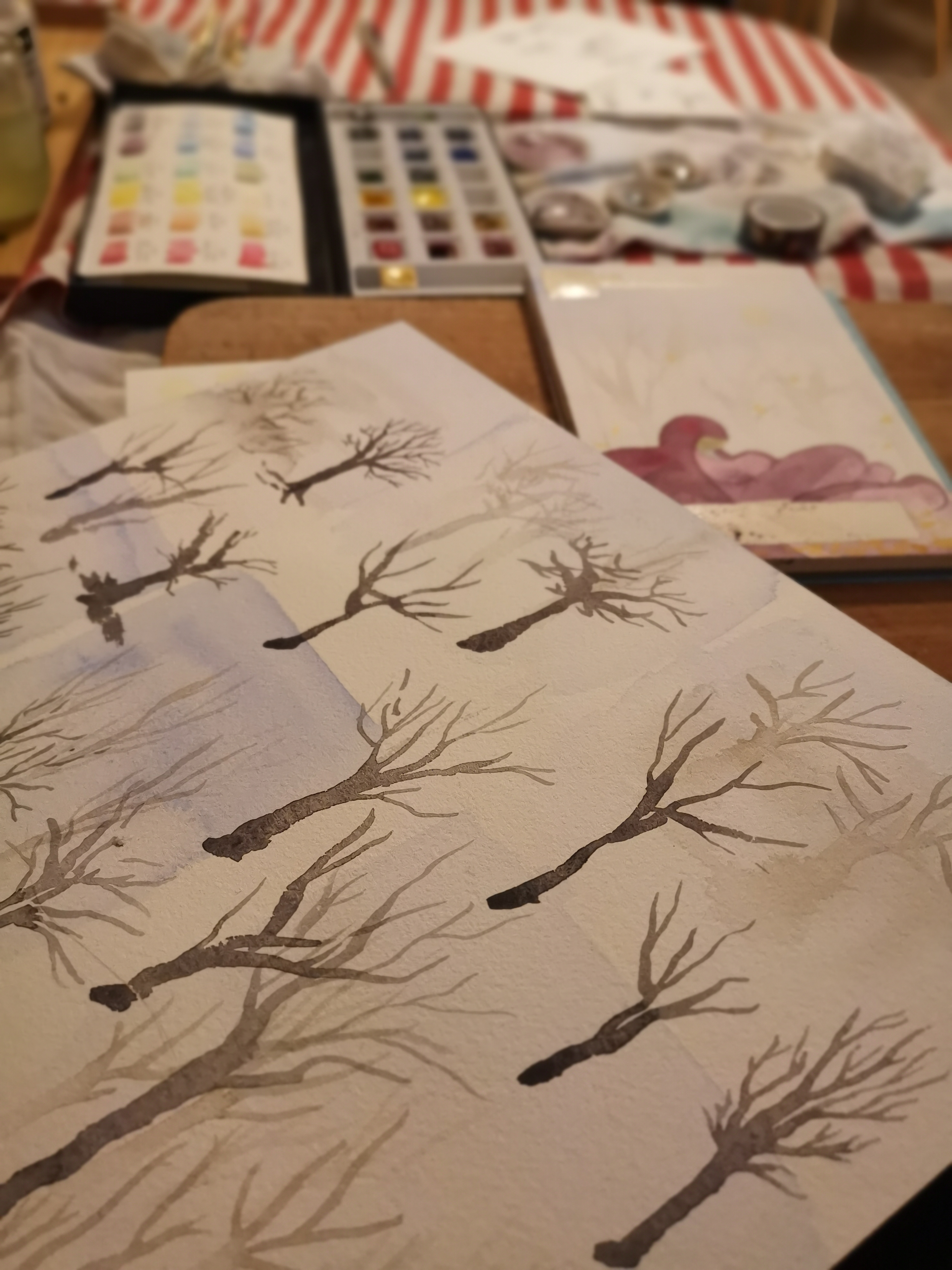 Des essais d'aquarelles illustrant des arbres nus